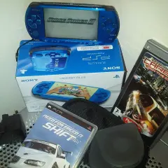 Niebieska konsola PSP z grą Ridge Racer 2, pudełko z konsolą i grami Need for Speed Shift i Carbon. Klasyczne stare gry na telefon.