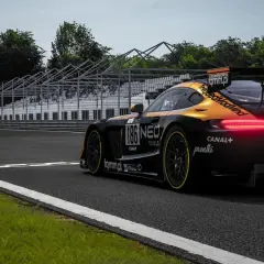 Czarny samochód wyścigowy z pomarańczowymi akcentami na torze. Widoczne logo "unSerious.pl", sugerujące polskie spolszczenie do Assetto Corsa.