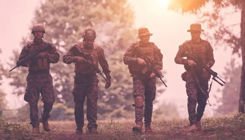 Czterech żołnierzy w kamuflażu, z karabinami, idzie przez las. Czy to przygotowanie do "Escape from Tarkov wymagania"?