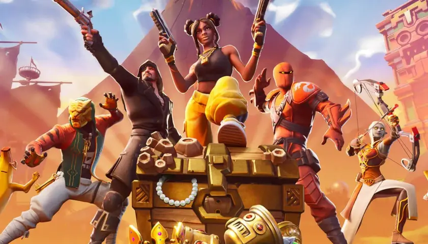 Postacie z gry Fortnite przy skrzyni pełnej skarbów. Idealne dla graczy szukających darmowe gry na PS4.