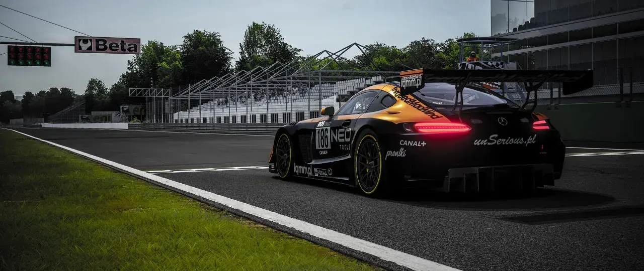 Czarny samochód wyścigowy z pomarańczowymi akcentami na torze. Widoczne logo "unSerious.pl", sugerujące polskie spolszczenie do Assetto Corsa.