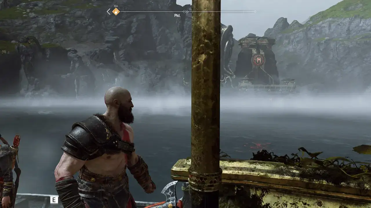 Kratos w remaster wersji gry God of War patrzy na mglisty krajobraz z kamiennymi budowlami.